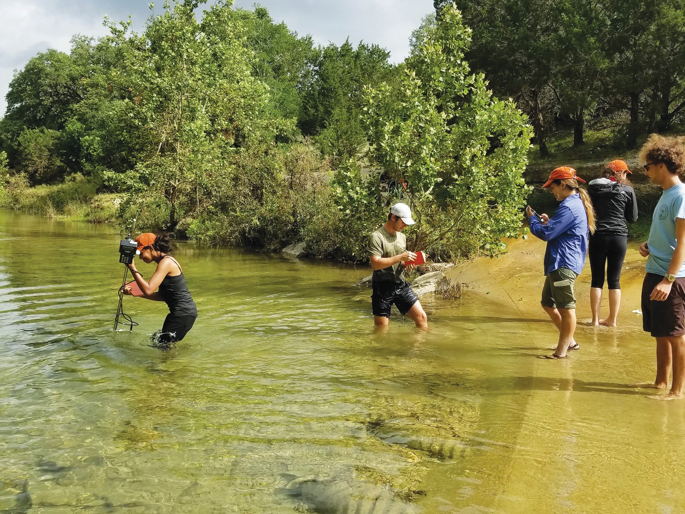 Students measure flow in South Onion Creek at the White Family Outdoor Learning Center 